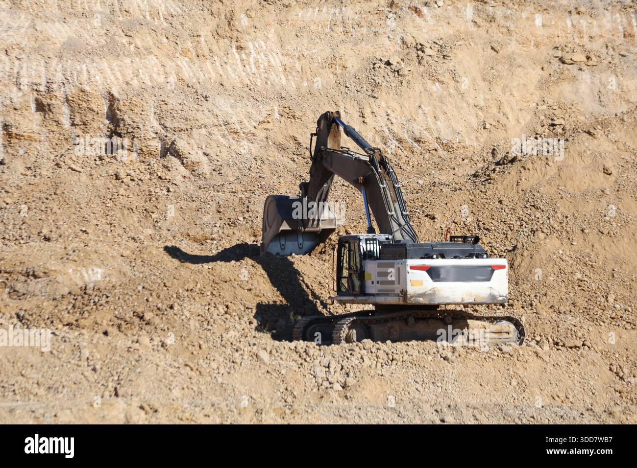 Escavatori pesanti che estraggono il materiale di riempimento da una cava per la costruzione di strade e progetti infrastrutturali Foto Stock