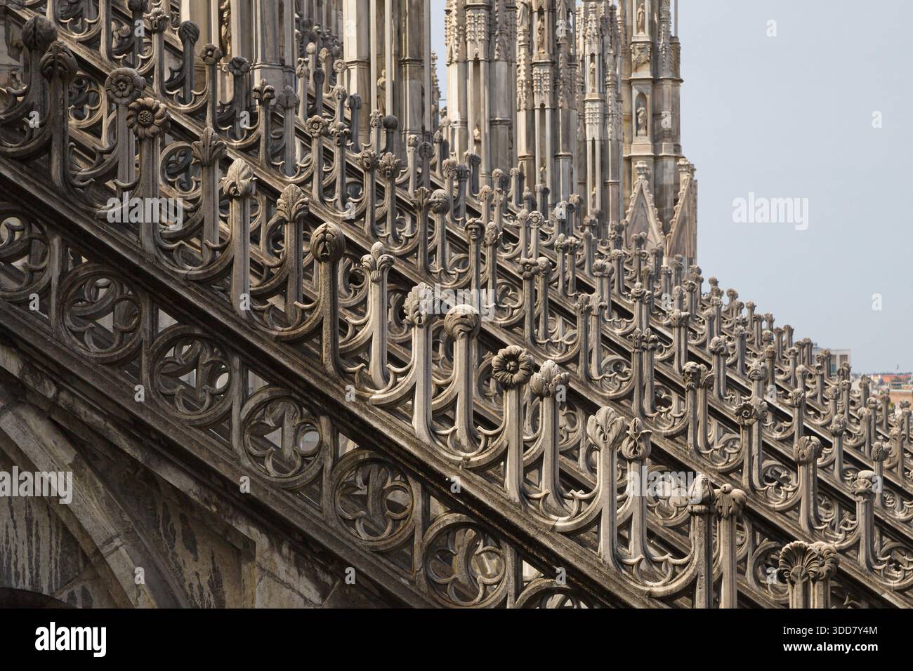 Contrafforti volanti decorativi del Duomo di Milano, che mostrano intricate opere in pietra gotica ed elementi scultorei disposti diagonalmente contro la S. Foto Stock