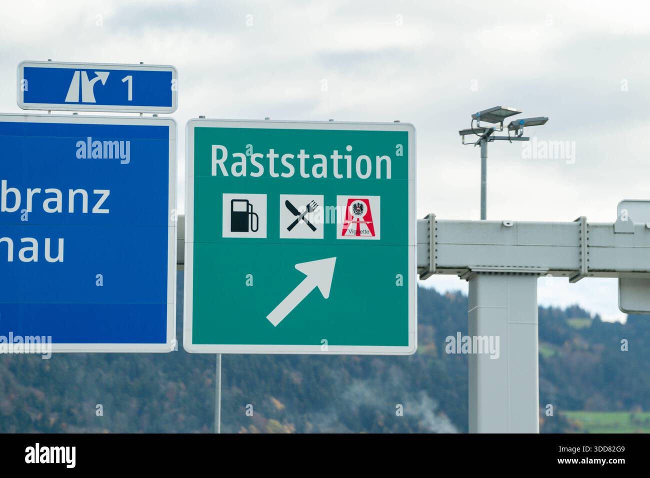 Raststation, Autobahn, Hörbranz, Österreich, Vorarlberg, Verkehrsschild, Raststätte, Tankstelle, ristorante, Vignette, Autobahnschild, Beschilderung, Rast, Pausa, Infrastruktur, Verkehr, Straßenverkehr, Fernstraße, Wegweiser, Autofahrt, Reiselust, Orientierung, Servicebereich, VerkehrsInformation, Straßenzeichen, Tankmöglichkeit, gastronomia, Maut, Autobahnnetz, Verkehrsfotografie, Verkehrstechnik, Beschilderungssystem, Rastmöglichkeit, Verkehrssicherheit, Autofahrer, Fernverkehr, Tourismus, Infrastruktur Österreich, Raststation Hörbranz, Autobahn A14, Alpenregion, Landschaft, Bergkulisse, Str Foto Stock