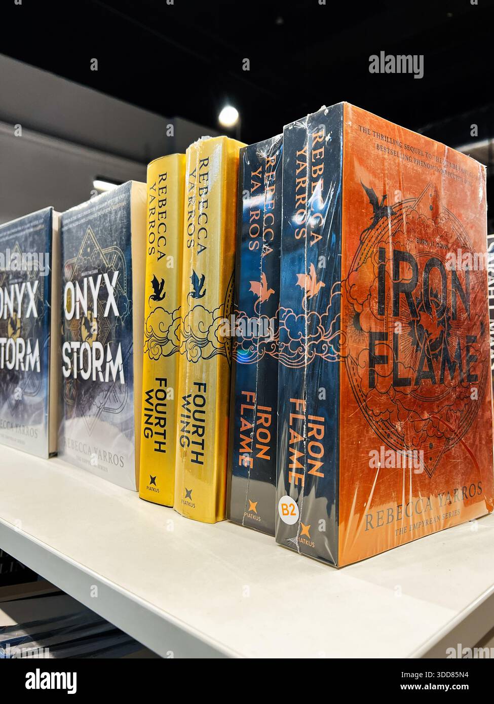 Londra, Regno Unito - 12 dicembre 2025: Una vivace serie di romanzi fantasy con copertine audaci e titoli drammatici sullo scaffale di una libreria. Foto Stock
