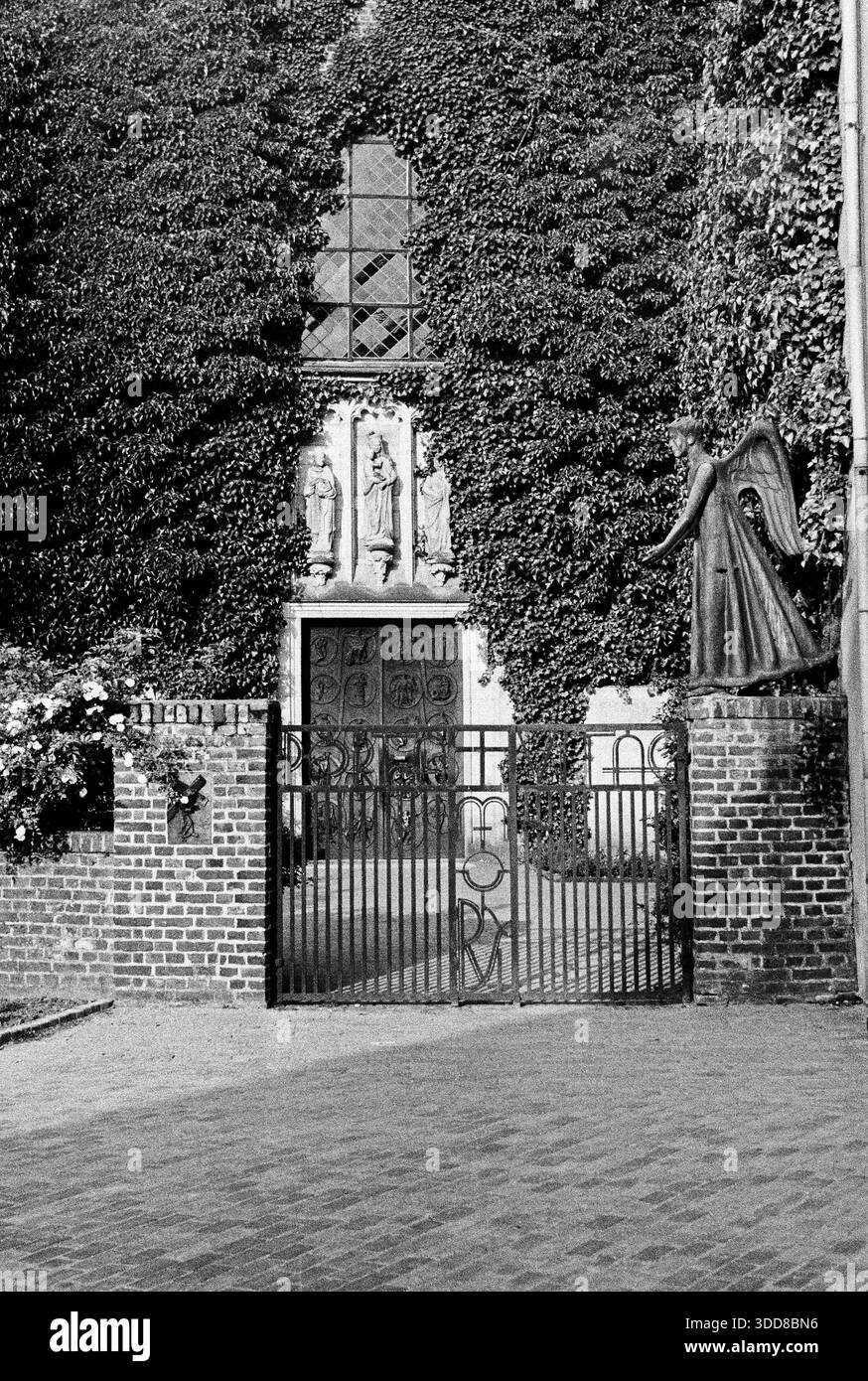 Sechzigerjahre, Juli 1965, Deutschland, Hamminkeln-Marienthal, Niederrhein, Nordrhein-Westfalen, NRW, Karmeliterkloster, Ehemals Augustiner-Eremiten, Klosterkirche Mariae Himmelfahrt, Portal, Pfortenengel, Bronzeengel von Eugen Senge-Platten, Spaetgotik Sechzigerjahre, Juli 1965, Deutschland, Hamminkeln, Issel, Naturpark Hohe Mark-Westmuensterland, Niederrhein, Rheinland, Nordrhein-Westfalen, NRW, Hamminkeln-Marienthal, Karmeliterkloster Marienthal, Ehemals Augustiner-Eremiten, Klosterkirche Mariae Himmelfahrt, Eingangsportal, Pfortenengel, Bronzeengel von Eugen Senge-Platten, Skulptur, Heilig Foto Stock