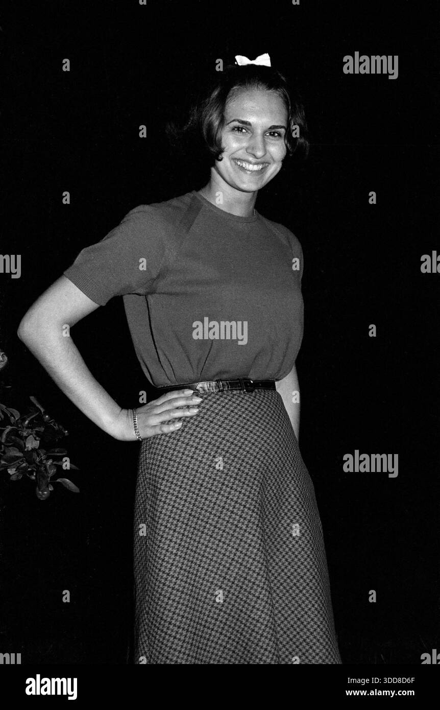 Sechzigerjahre, 28.05.1966, Deutschland, Menschen, Frauen, Maedchen 17 bis 20 Jahre, Fotoshooting im Garten bei Nacht, Pullover und Rock, mittellanges Haar, Angelika Sechzigerjahre, 28.05.1966, Deutschland, Menschen, Frauen, Maedchen 17 bis 20 Jahre, Fotoshooting im Garten bei Nacht, Pullover und Rock, mittellanges Haar, Medium Shot, Seitenansicht, stehend, Haende in die Hueften gestemmt, lachend, Angelika, Sessanta, 28.05.1966, Germania, persone, donne, ragazza dai 17 ai 20 anni, foto in giardino di notte, maglione e gonna, capelli di media lunghezza, foto di media lunghezza, vista laterale, in piedi, mani nella h Foto Stock
