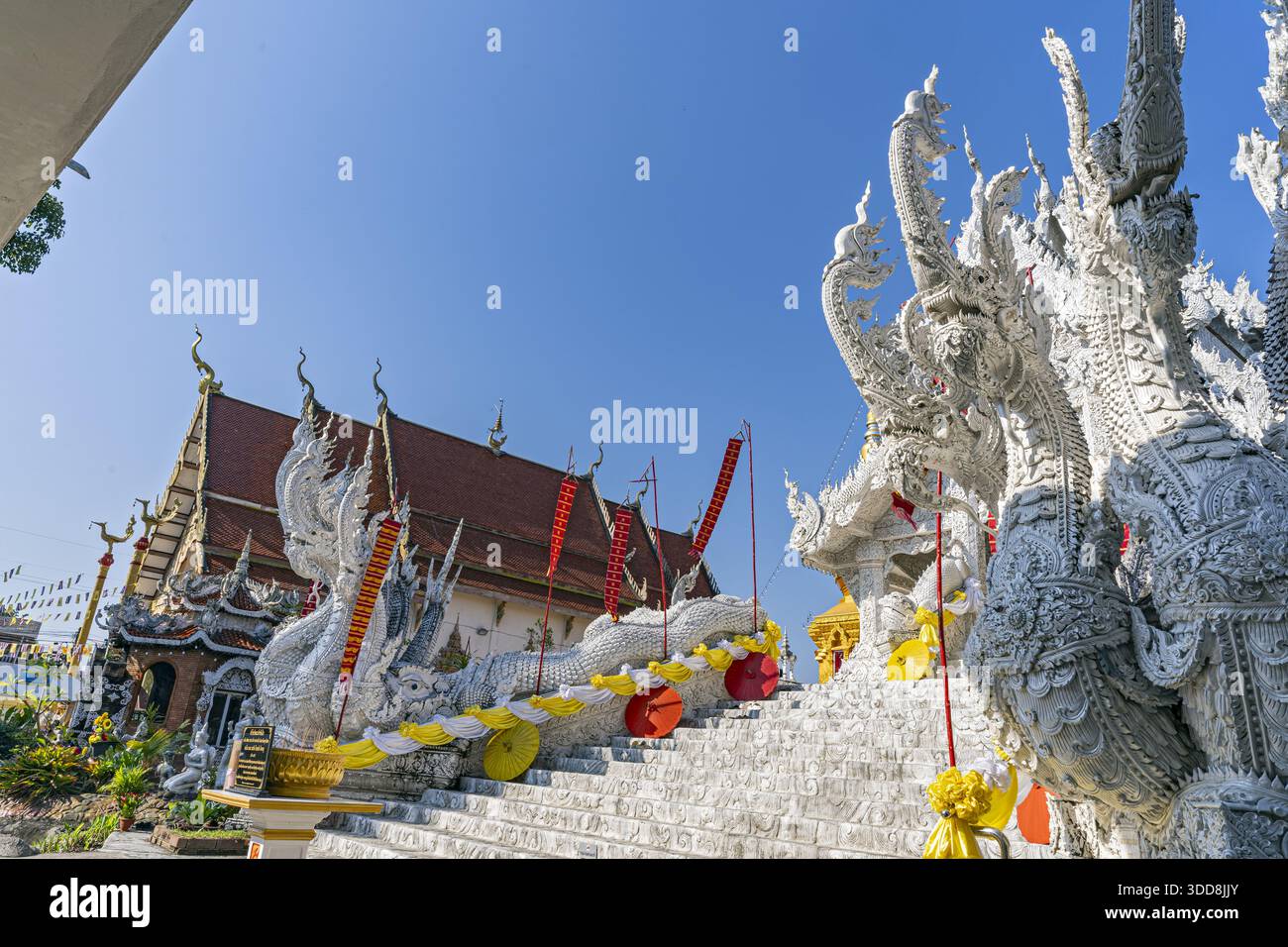 DOK KHAM TAI, PHAYAO, THAILANDIA - 29 DICEMBRE 2025: Tempio di Sri Chum, serpente di White Naga, fiancheggiano le scale che conducono ad un tempio con un tetto rosso Foto Stock