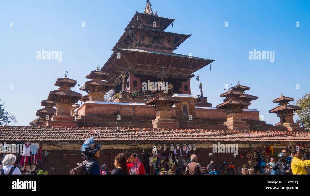Grande pagoda che sorge sopra una vivace area del mercato sotto un cielo azzurro. Foto Stock