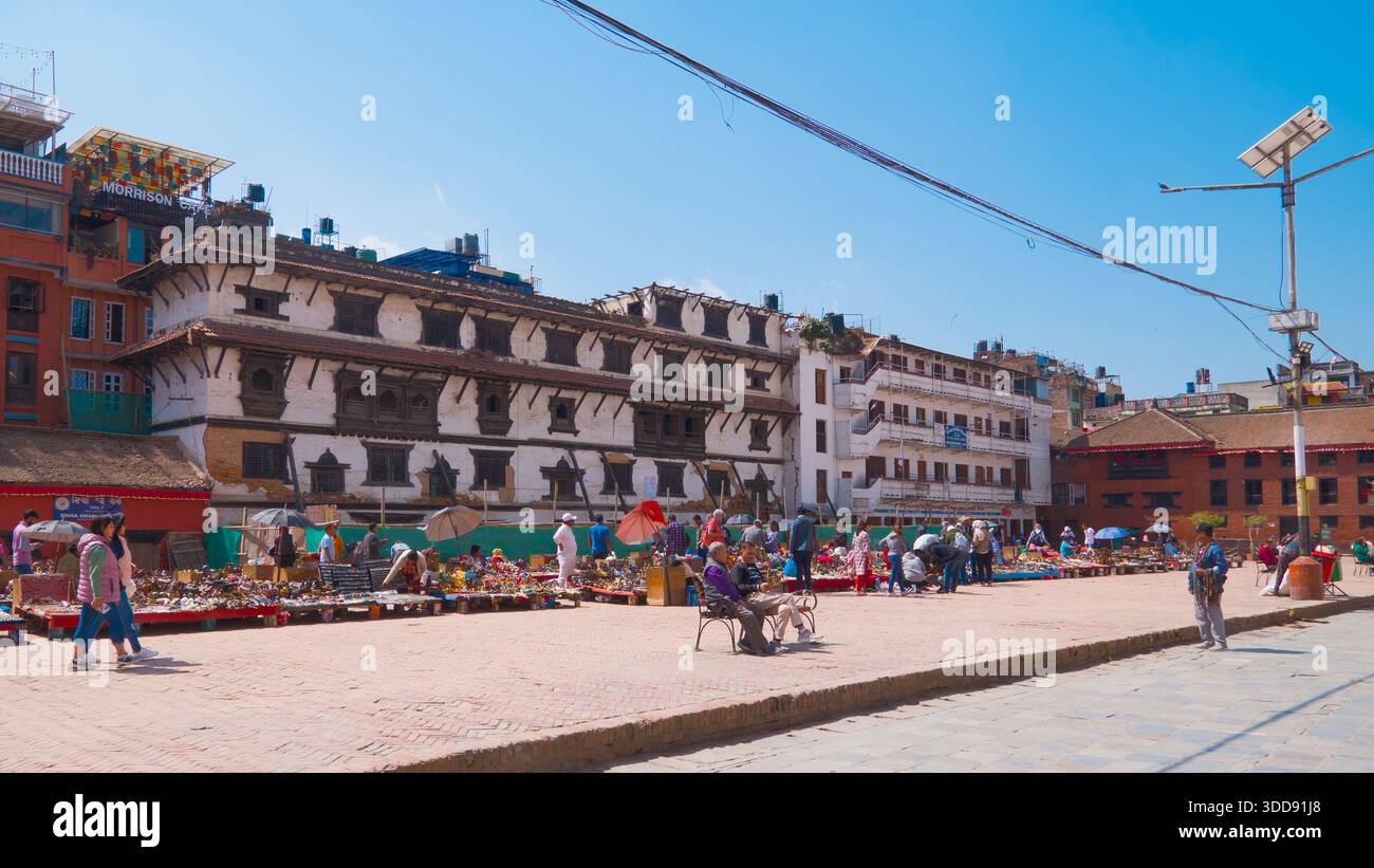Le persone si rilassano in una spaziosa piazza circondata da edifici storici, godendo della vita urbana e del patrimonio culturale. Foto Stock