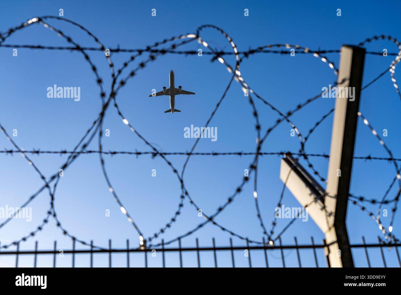 Immagine simbolica della sicurezza all'aeroporto, recinzione esterna all'aeroporto internazionale di Düsseldorf, recinzione in filo d'acciaio con rotoli S-wire, filo NATO sulla recinzione Foto Stock