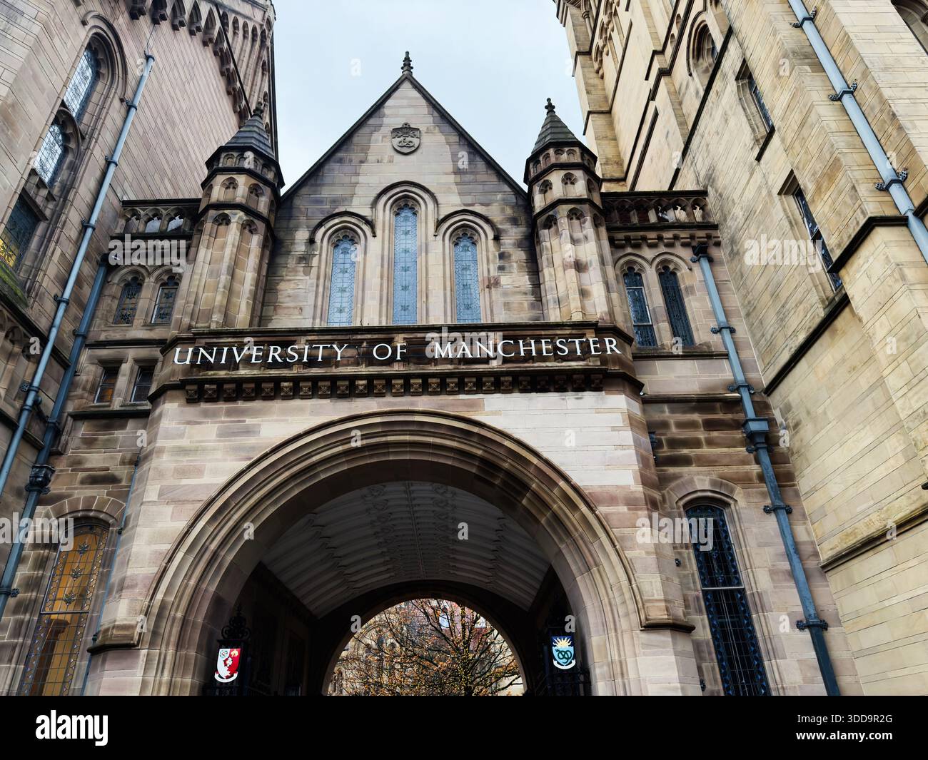Manchester, Regno Unito - 06 dicembre 2025: La grande arcata in pietra incornicia lo storico campus dell'Università di Manchester a Manchester nel Regno Unito. Foto Stock
