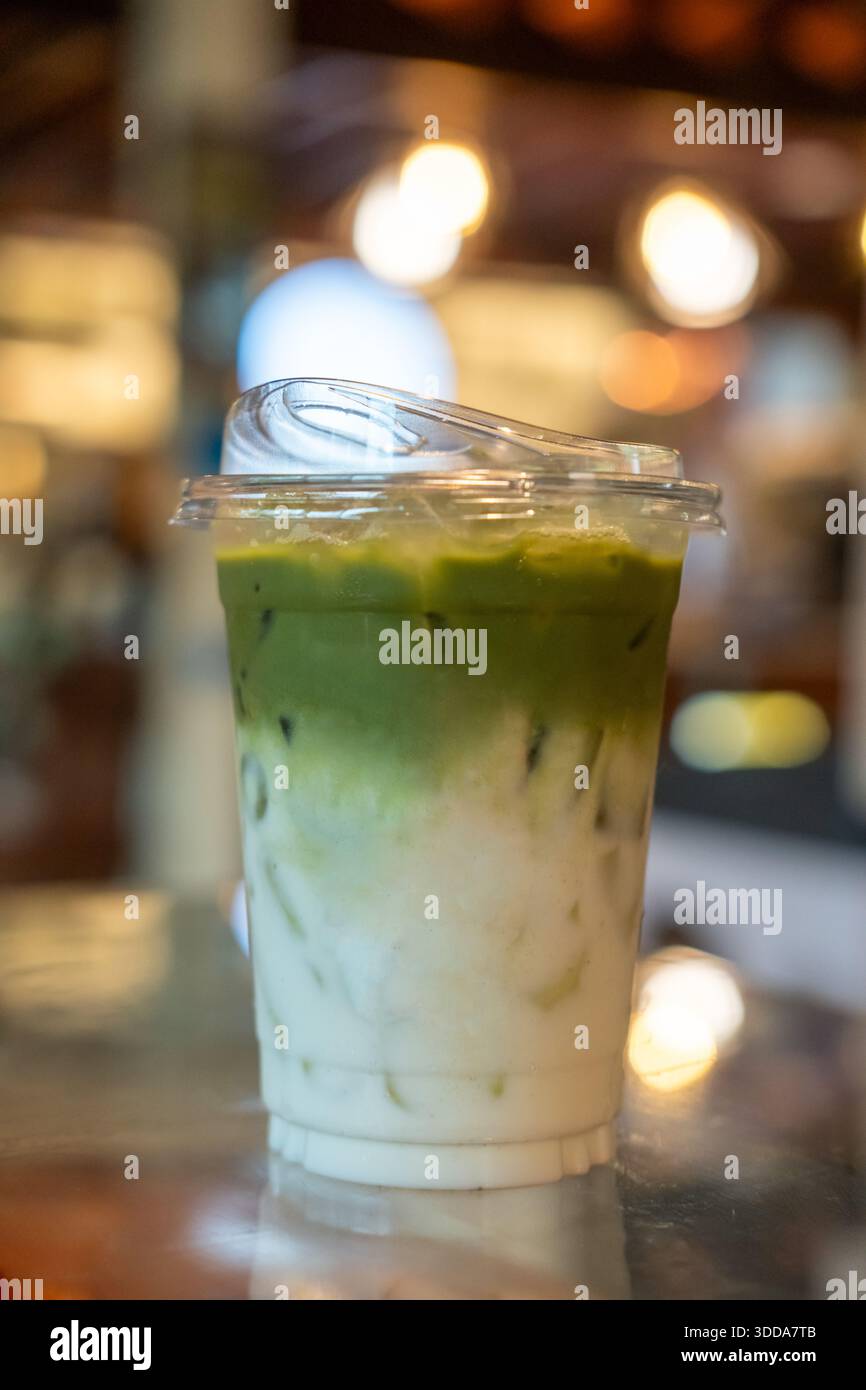 Una tazza di latte di tè verde ghiacciato, sul tavolo Foto Stock