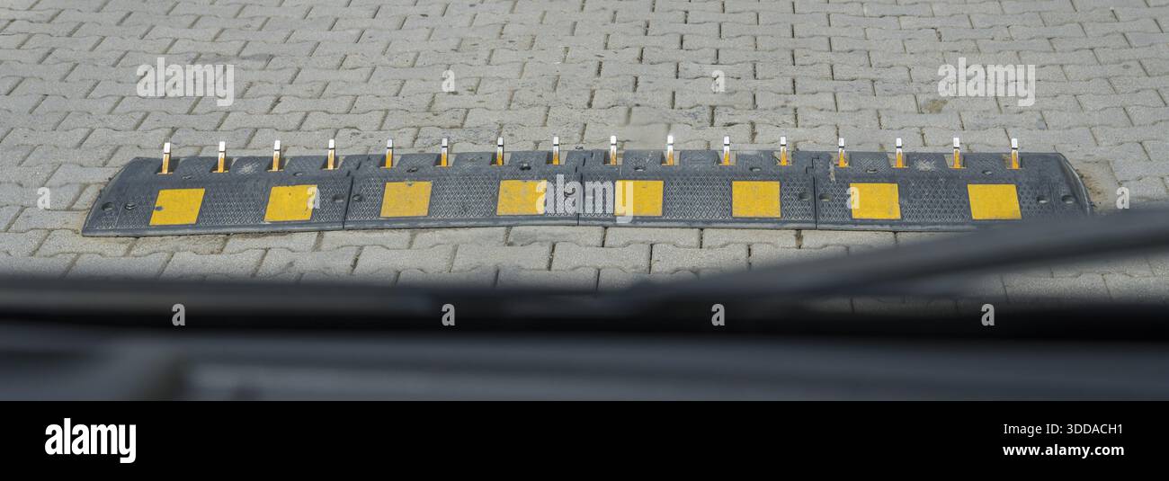 Ostruzione del terreno con segnaletica gialla su una strada asfaltata, problemi di velocità unidirezionale con picchi sulla strada, picchi stradali in acciaio, distrugge gli pneumatici se si corre Foto Stock