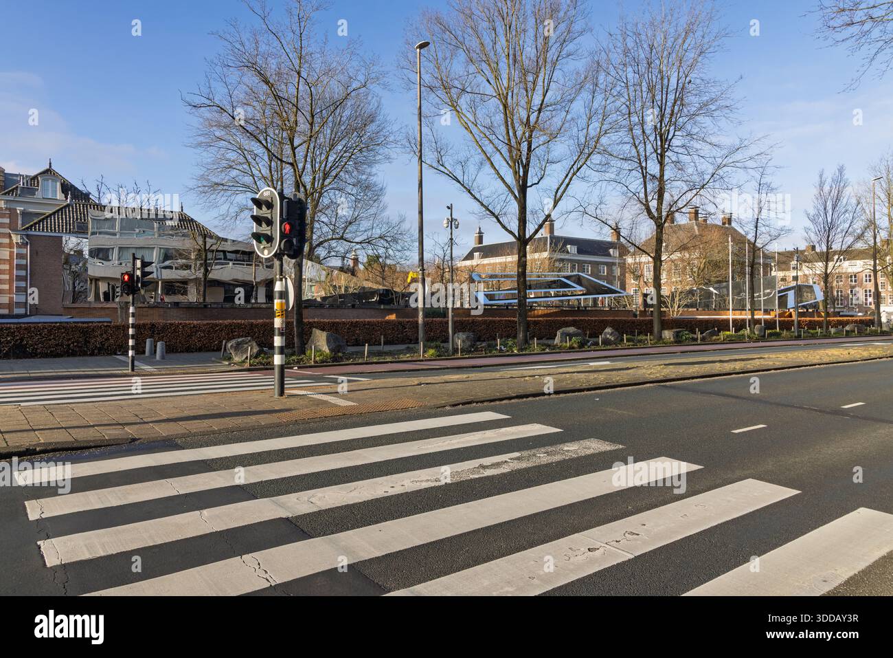 Vista sulla strada di un incrocio su Weesperstraat con le pareti specchiate del National Holocaust Names Monument sullo sfondo. Foto Stock