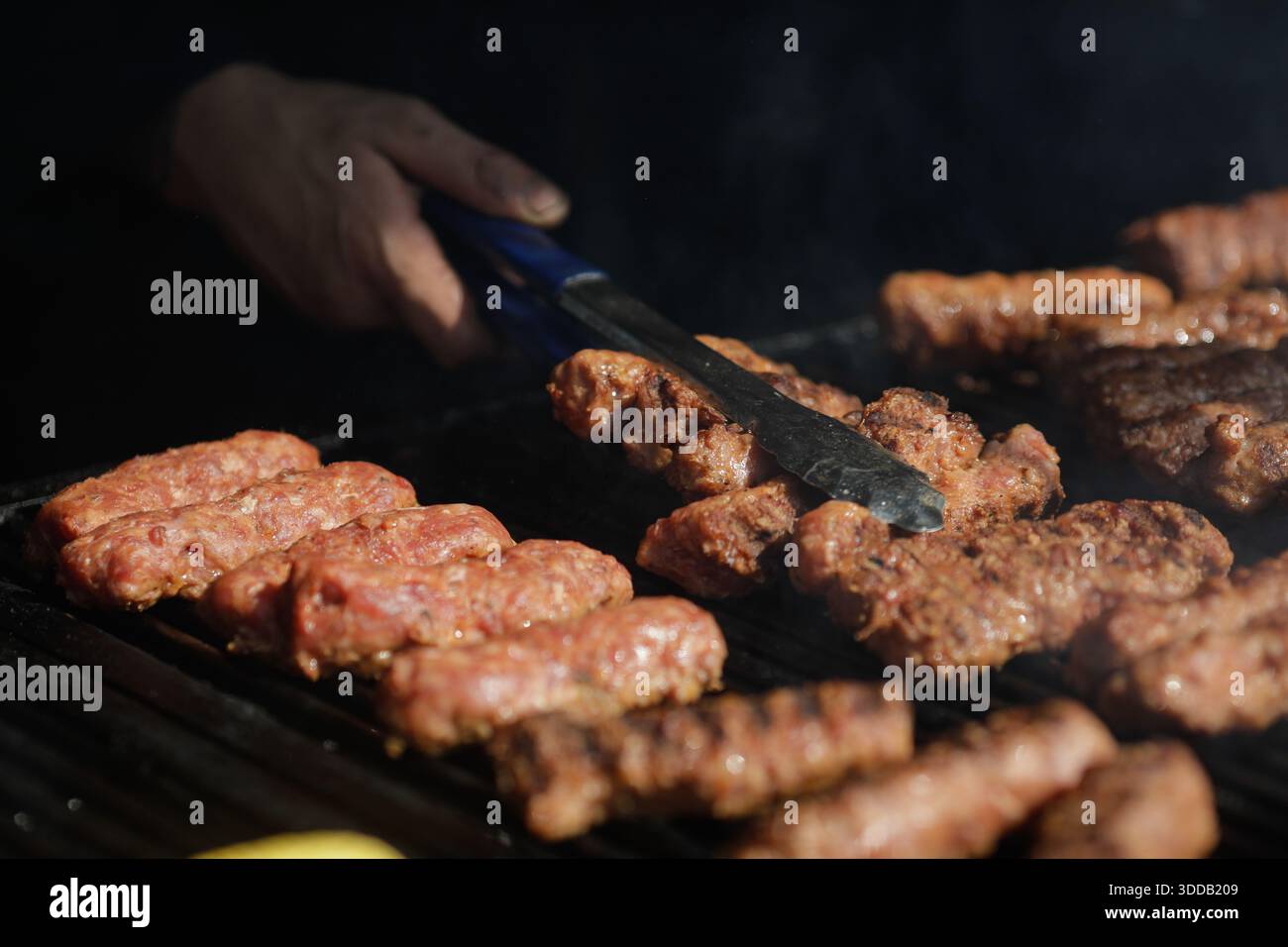 mici tradizionali rumeni (mititei o carne macinata laminata) su una griglia esterna in metallo carbone. Foto Stock