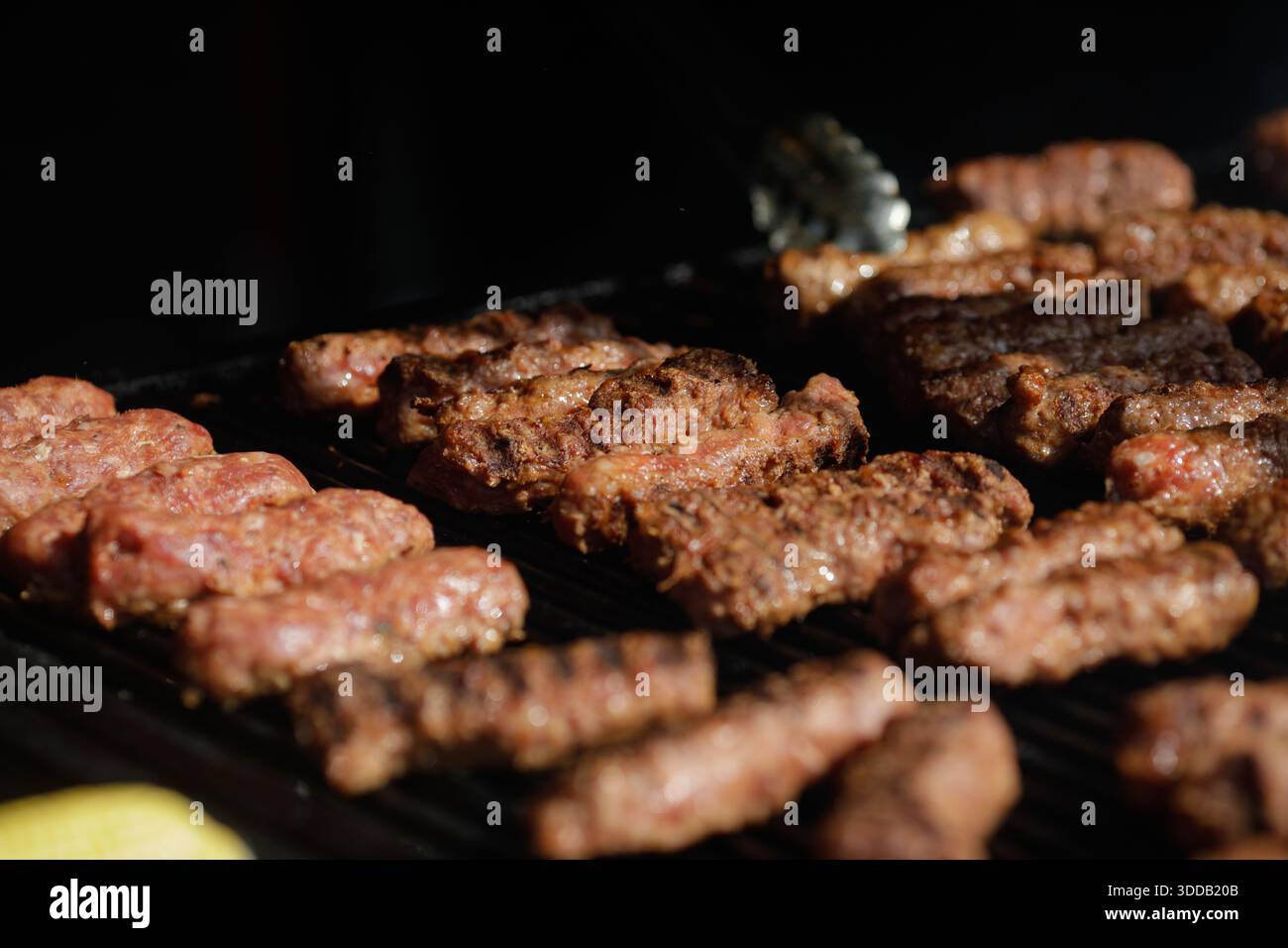 mici tradizionali rumeni (mititei o carne macinata laminata) su una griglia esterna in metallo carbone. Foto Stock