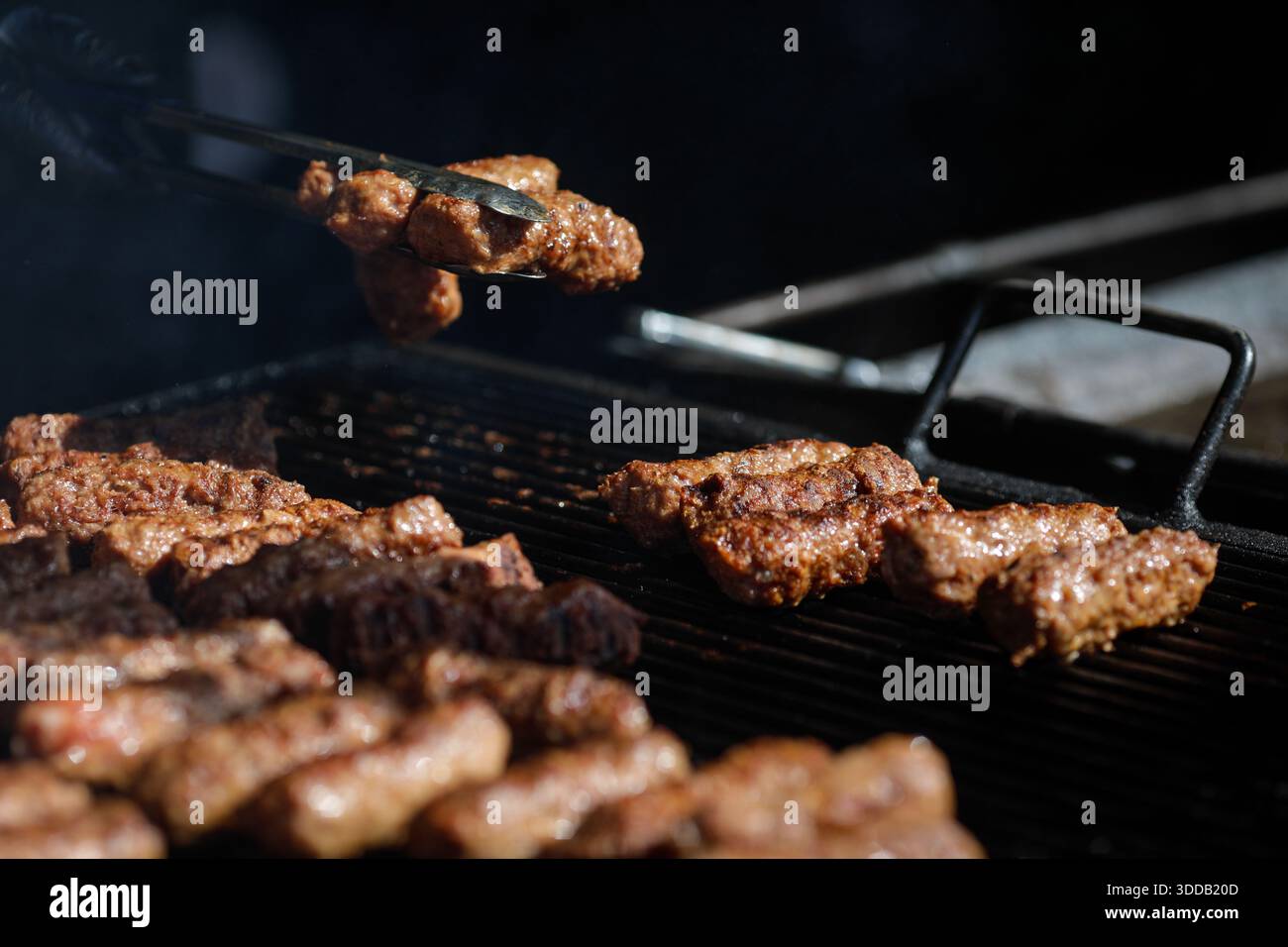 mici tradizionali rumeni (mititei o carne macinata laminata) su una griglia esterna in metallo carbone. Foto Stock