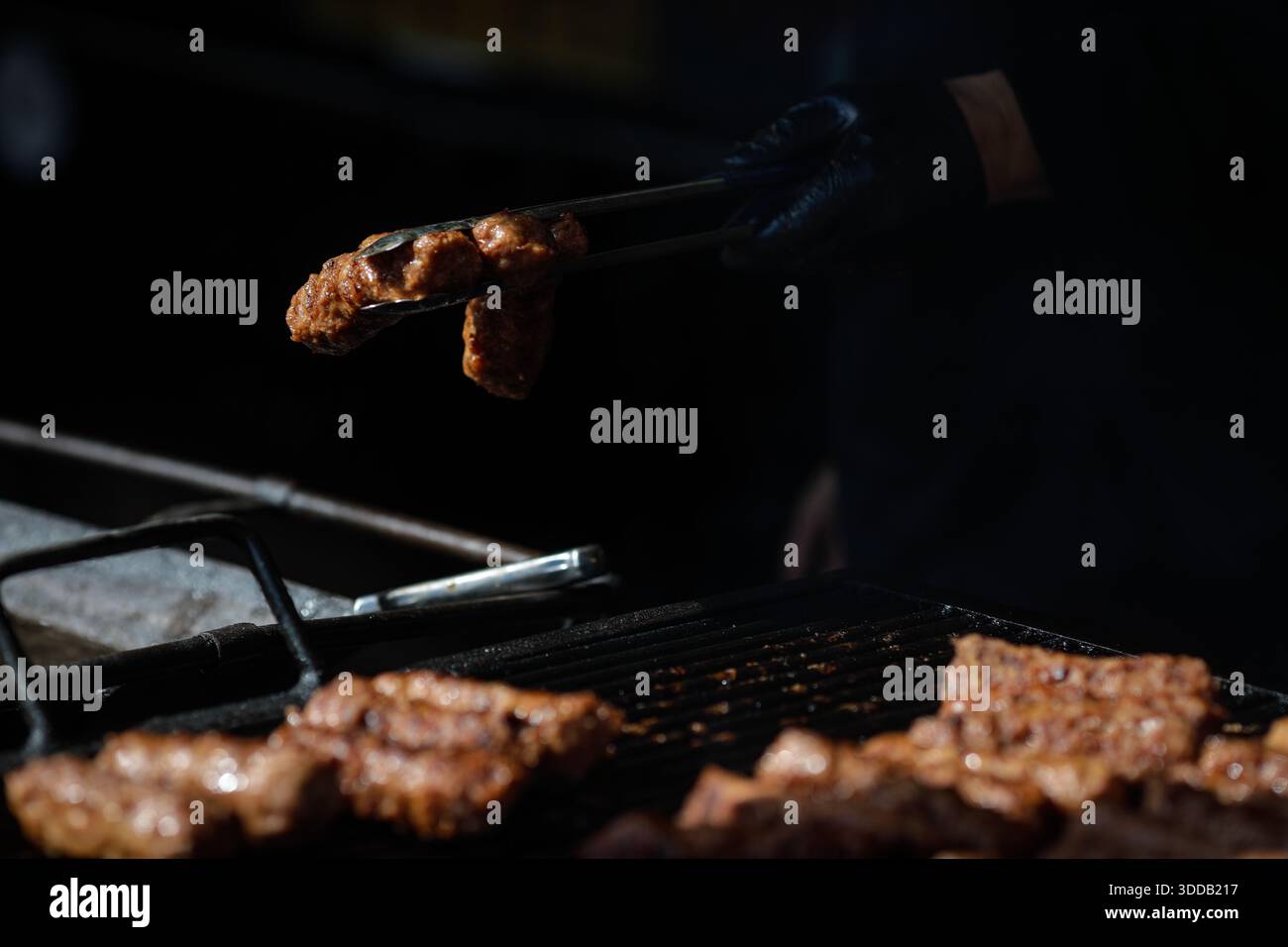mici tradizionali rumeni (mititei o carne macinata laminata) su una griglia esterna in metallo carbone. Foto Stock