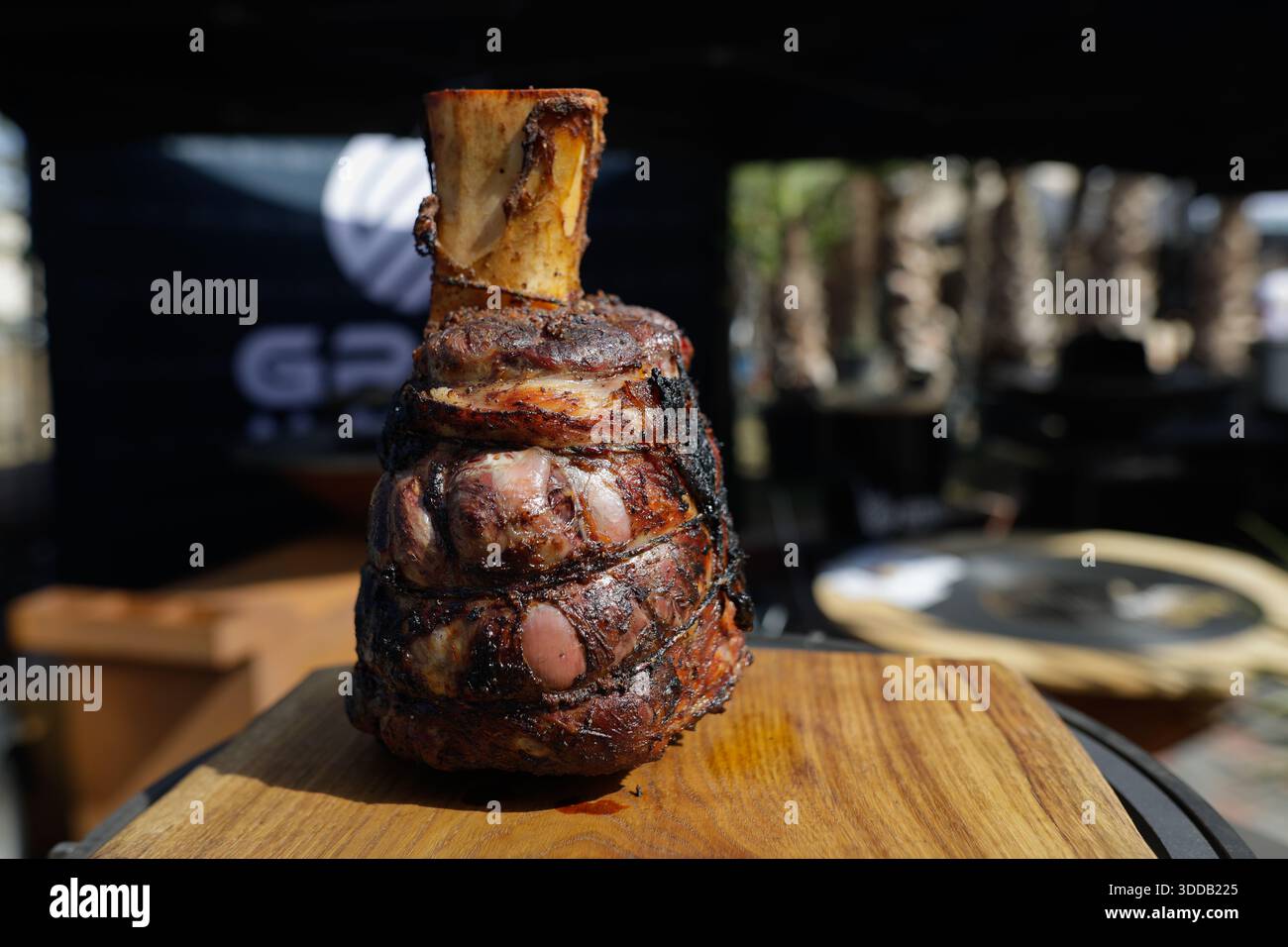 Il manzo arrosto si snoda su un tavolo di legno all'aperto in una giornata di sole. Foto Stock
