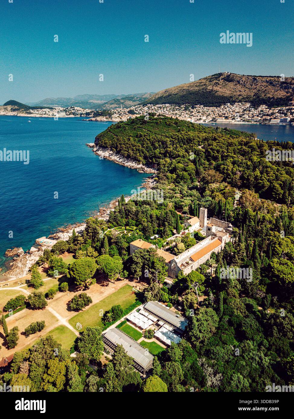 Vista aerea di un tranquillo monastero immerso in una vegetazione lussureggiante che incontra il mare azzurro, una fuga serena sull'isola di Lokrum, Dubrovnik, Dubrovnik-Neretva Foto Stock