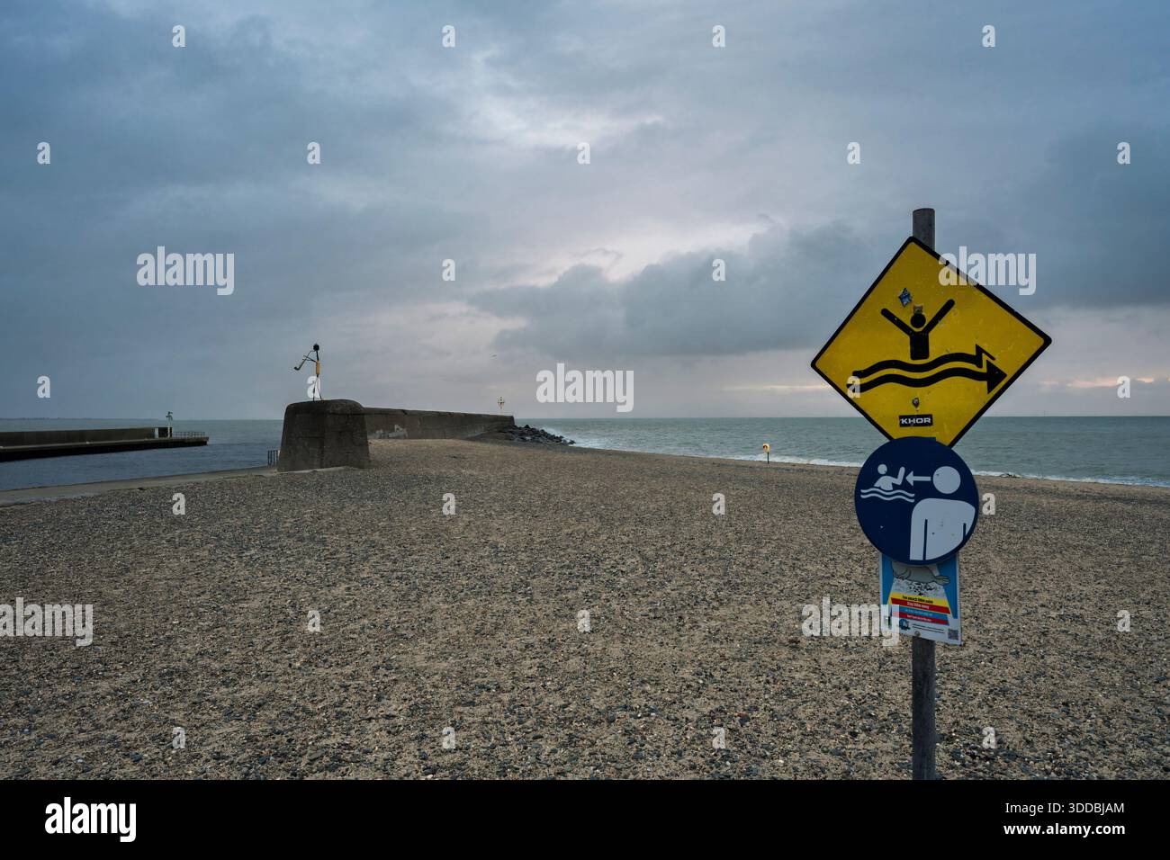 Arklow Pier e segnali di pericolo e soccorso sulla spiaggia della bocca del fiume Avoca con molo in cemento e mare coperto. Foto Stock