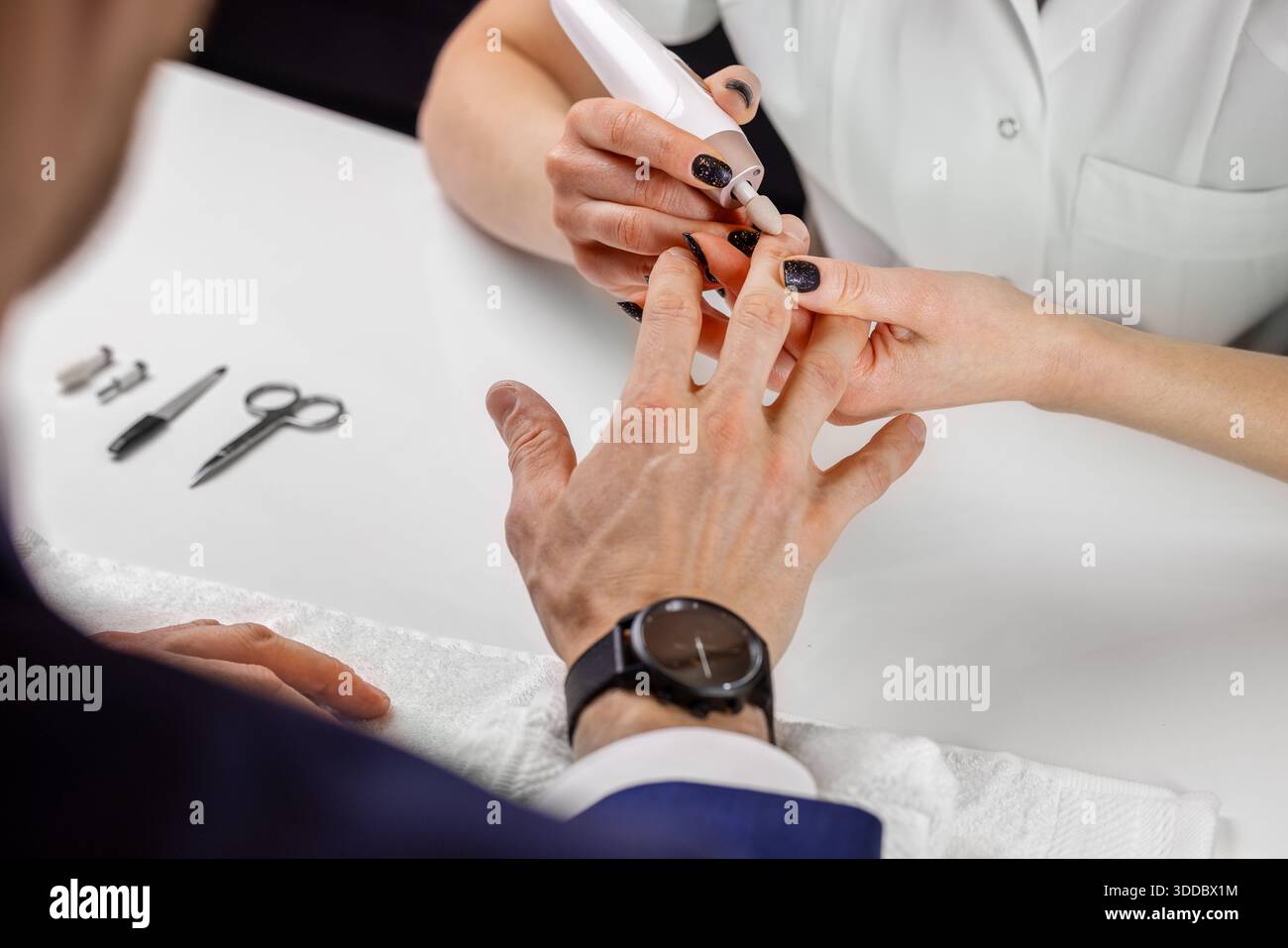 Maestro di manicure che lavora con un cliente maschile nel salone di bellezza. La cura delle unghie degli uomini Foto Stock