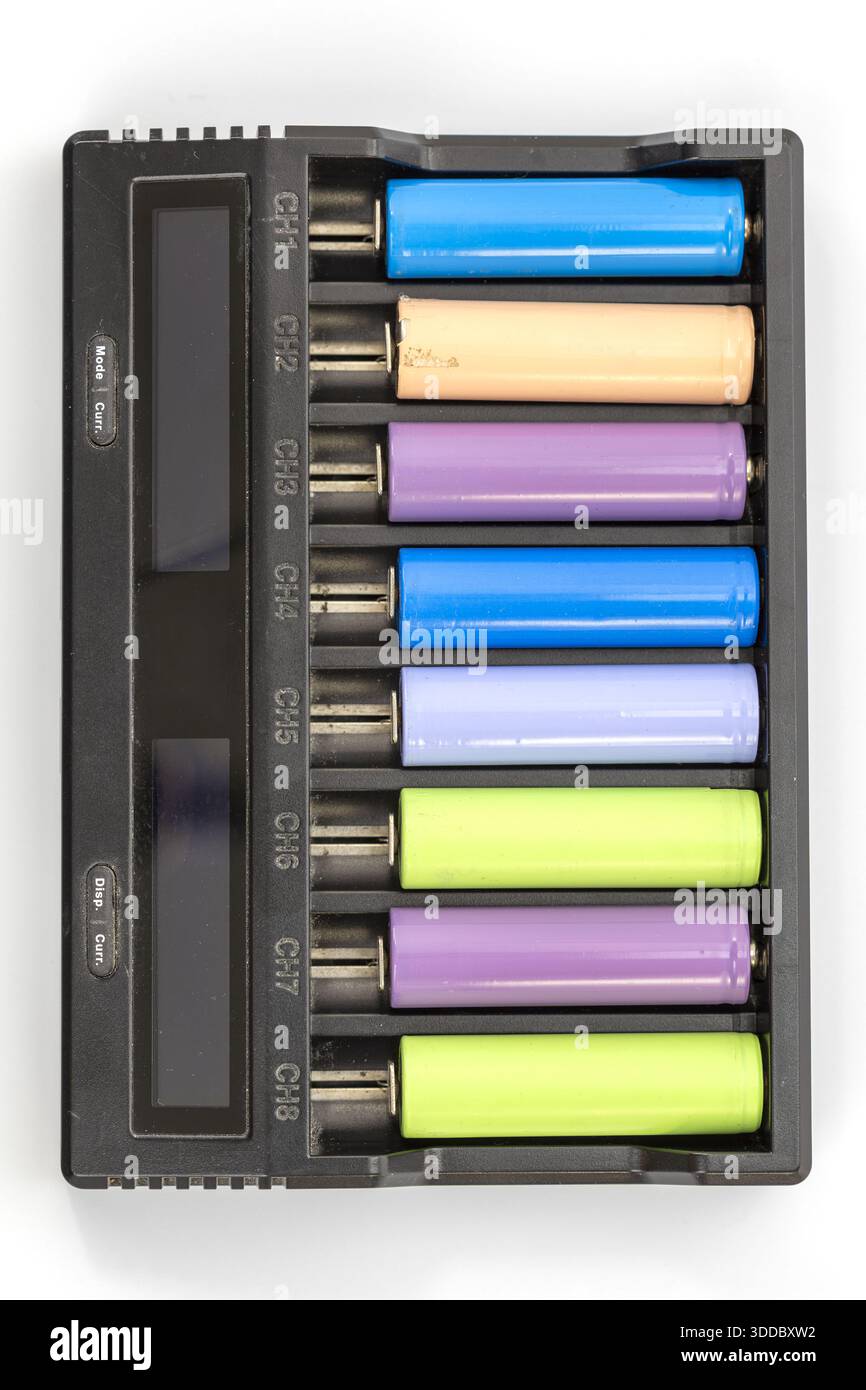 Vista dall'alto di un caricabatteria a otto canali con batterie di vari colori inserite. Il caricabatterie è in plastica nera e mostra le etichette dei canali CH1 Foto Stock