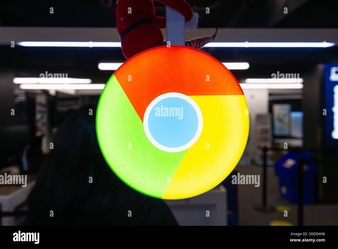 Logo del browser Google Chrome visualizzato su un cartello circolare illuminato all'interno di un moderno interno pubblico, che rappresenta il marchio Internet Foto Stock