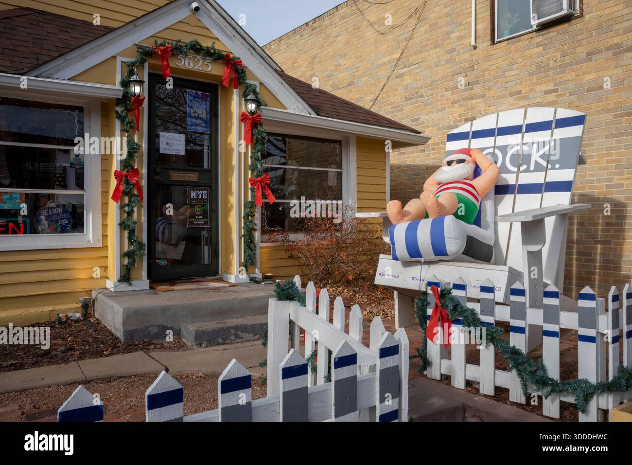 Arvada, Colorado - Un Babbo Natale gonfiato in una sdraio fuori da un negozio a Olde Town Arvada quando la temperatura ha raggiunto i 70F la vigilia di Natale. Foto Stock