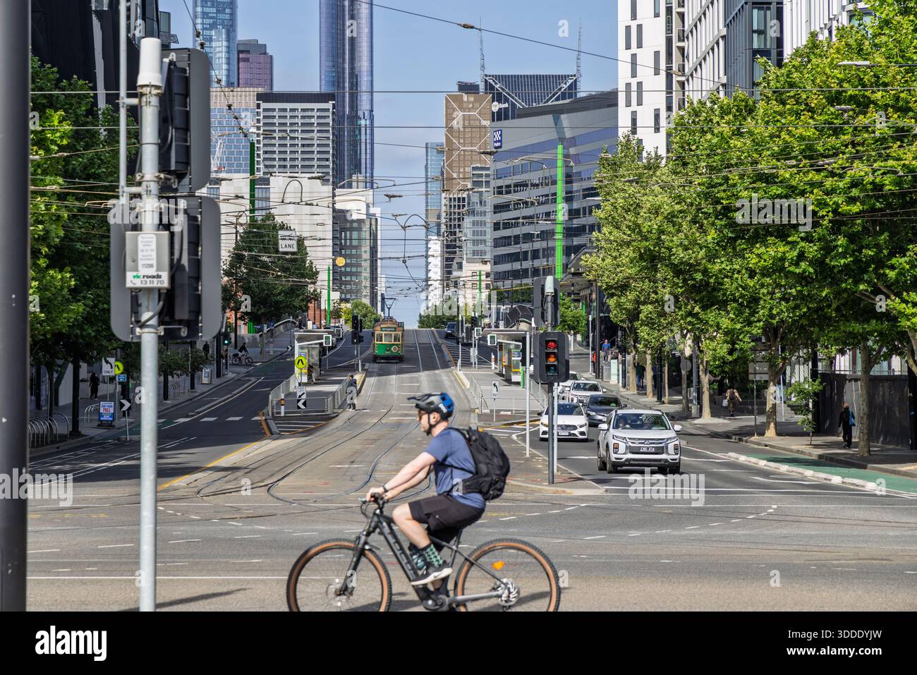 Ciclista che attraversa di fronte al tram scendendo dalla collina su la Trobe Street, Melbourne, Australia il 15 dicembre 2025 Foto Stock