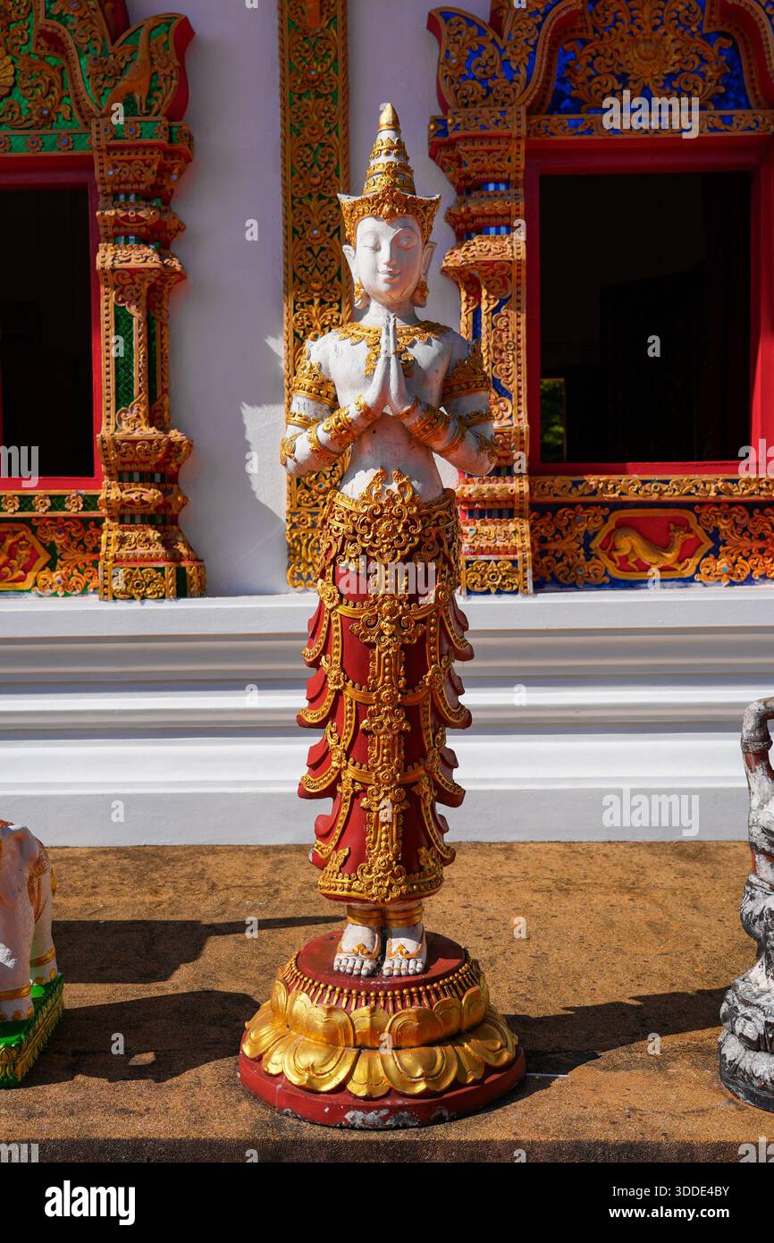 Statua dell'angelo Thep Phanom in una posizione rispettosa di Wai al tempio Wat Phra That Doi Tung vicino a Chiang Rai, nel nord della Thailandia Foto Stock
