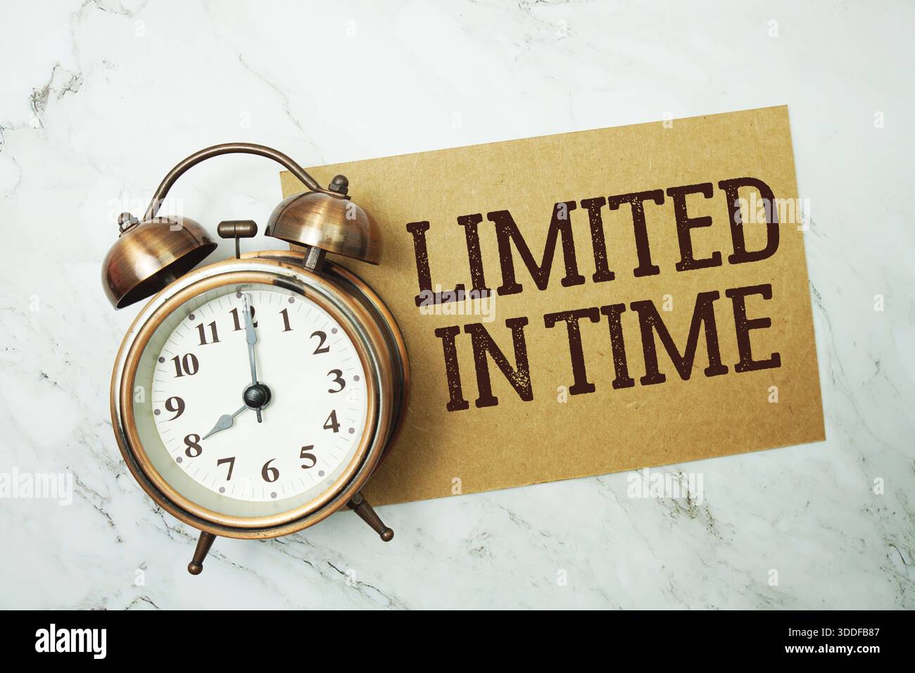 Testo scritto su carta con funzione limitata nel tempo e sveglia su sfondo in marmo Foto Stock