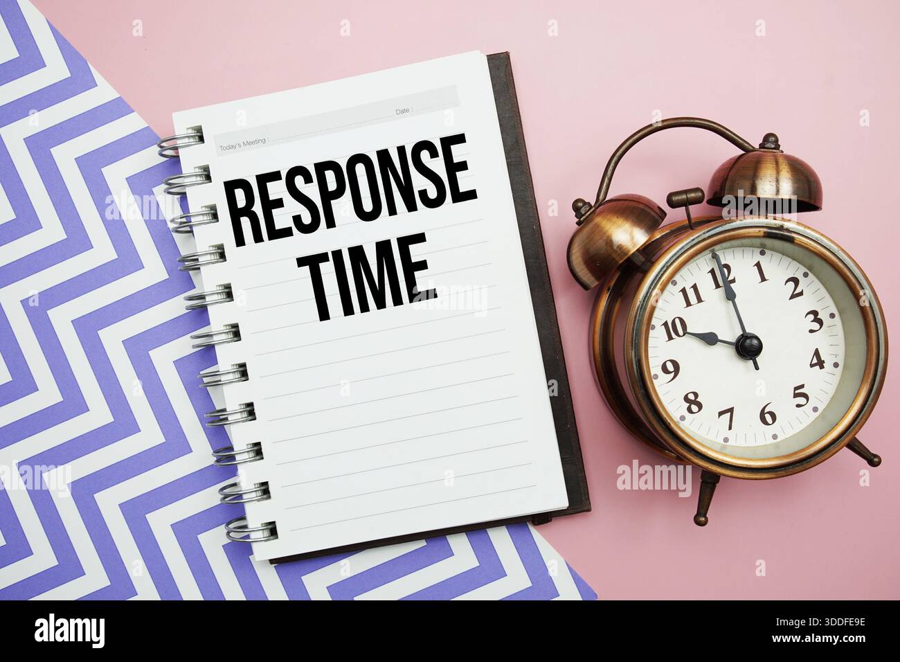 Testo del tempo di risposta scritto sul blocco note con sveglia Foto Stock