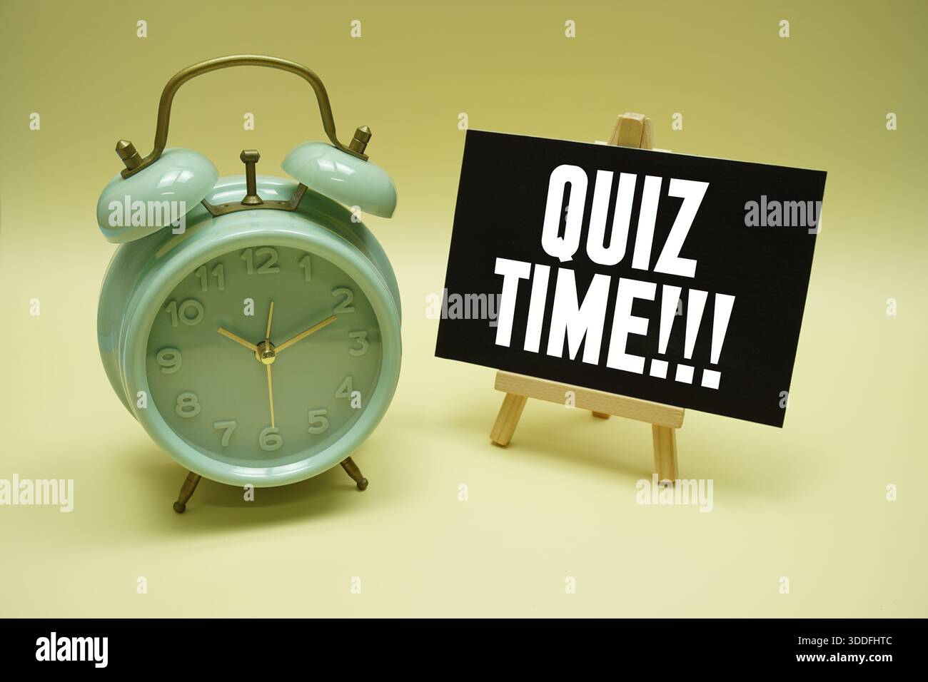 Messaggio di testo dell'ora del quiz e sveglia su sfondo giallo Foto Stock