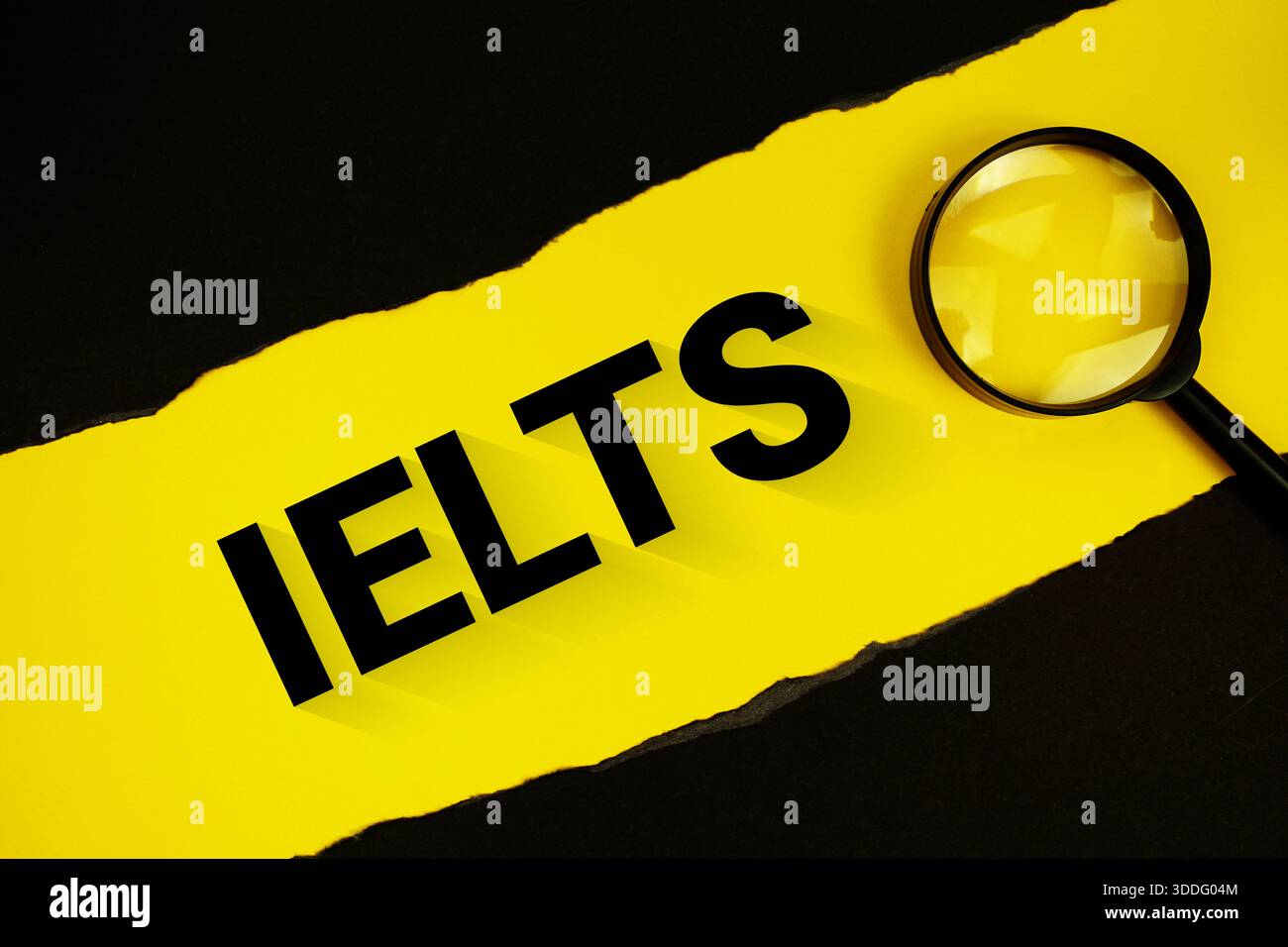 Testo IELTS su giallo con carta nera strappata e lente di ingrandimento Foto Stock