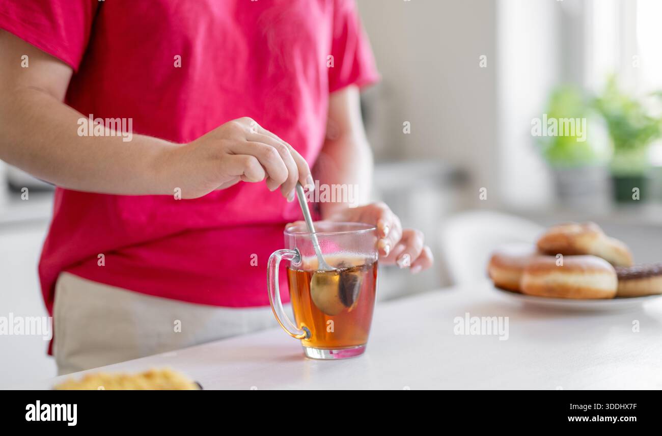La donna mescola il tè da Una borsa in primo piano Foto Stock