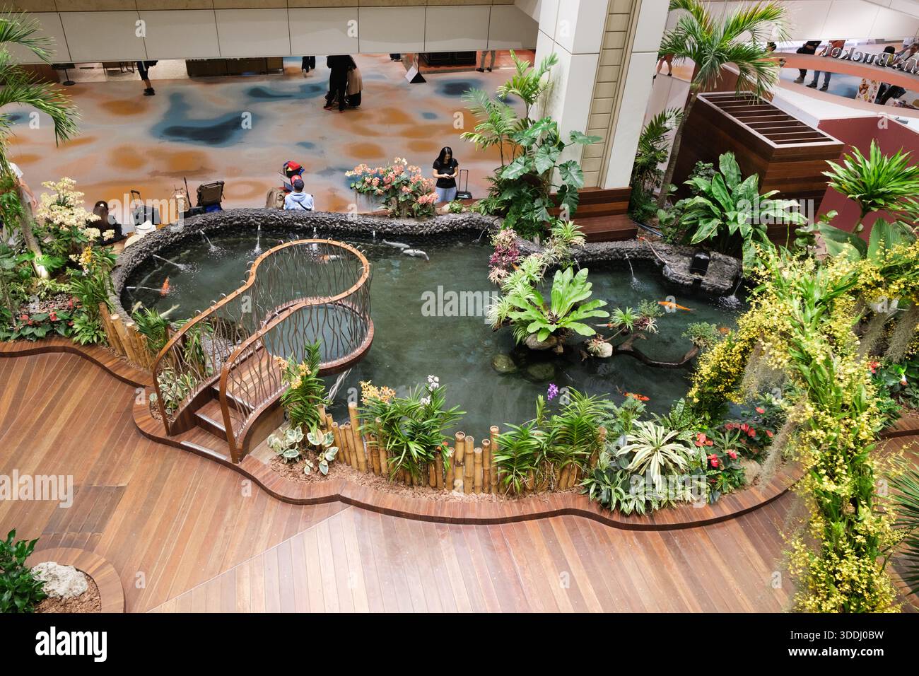 Singapore - 3 ottobre 2025: Il giardino interno dell'aeroporto di Changi presenta un tranquillo laghetto, sentieri in legno e lussureggianti piante tropicali, creando un'atmosfera tranquilla Foto Stock
