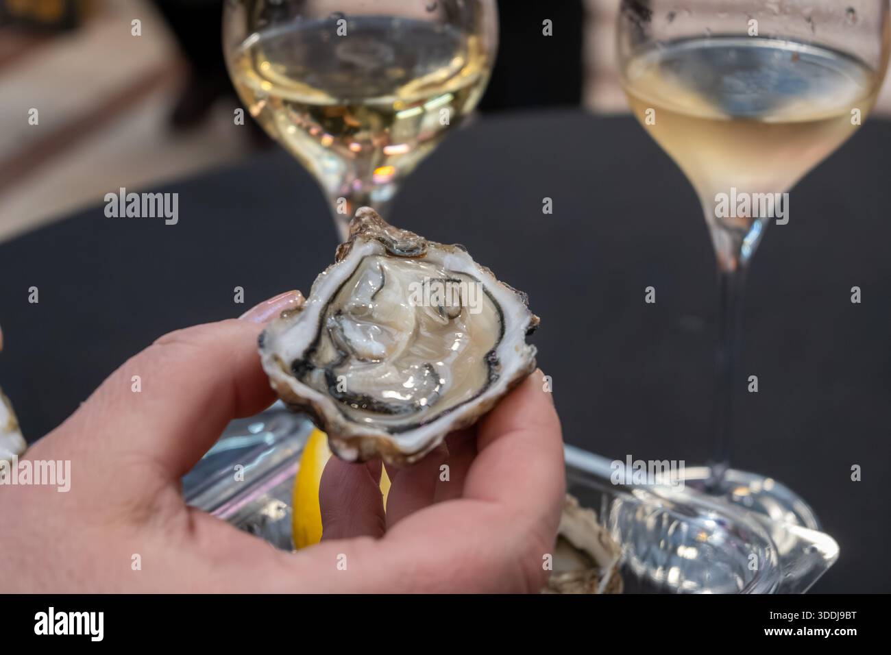 Ostriche fresche in conchiglie sul mercato francese settimanale, cibo di strada, porzione di ostriche vive aperte con un pezzo di limone da mangiare sul mercato, pesce, Francia Foto Stock
