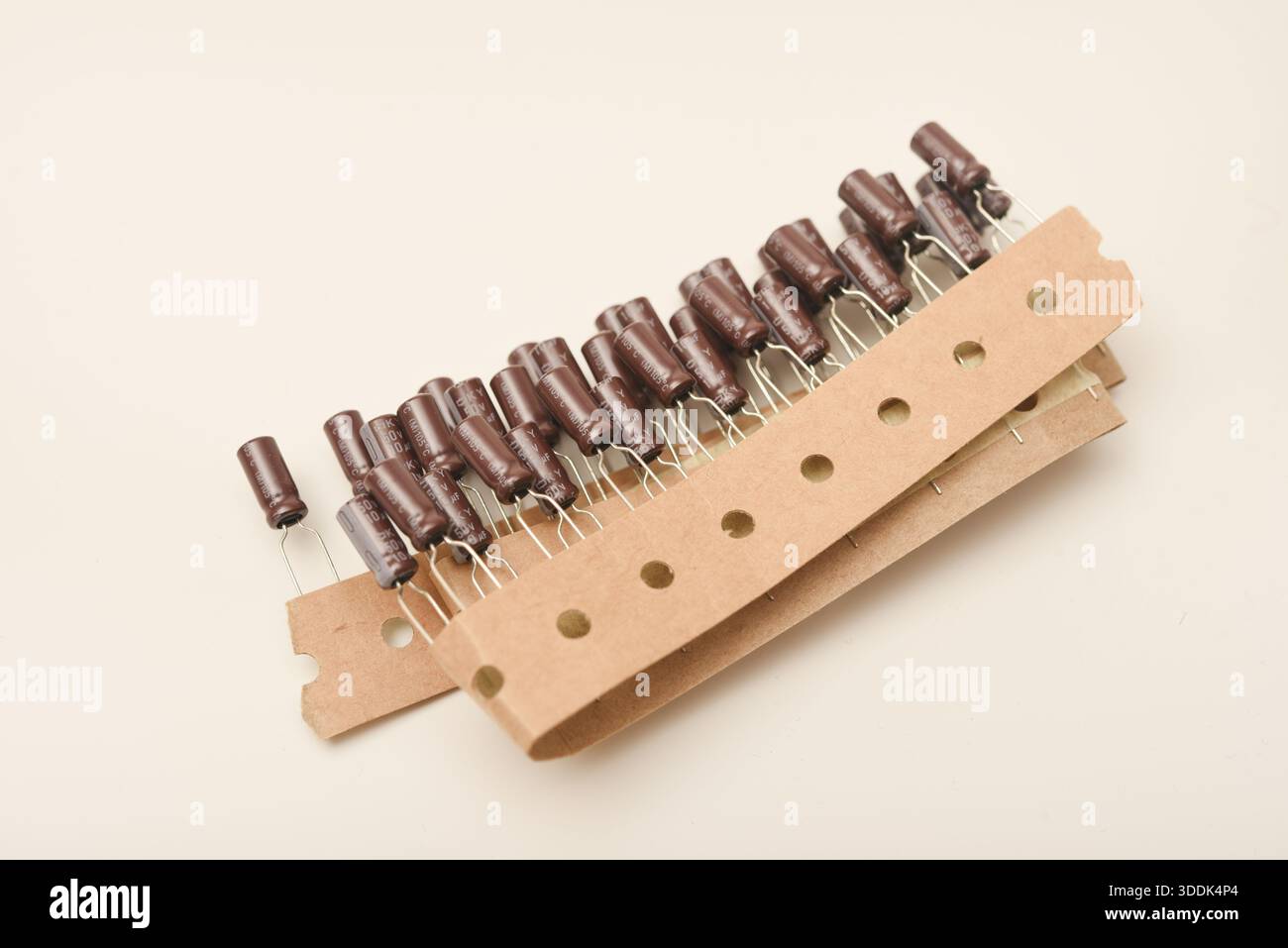 Vecchi condensatori in nastro di carta. Condensatori in alluminio su sfondo bianco. I componenti elettronici si trovano nella confezione originale. Foto Stock