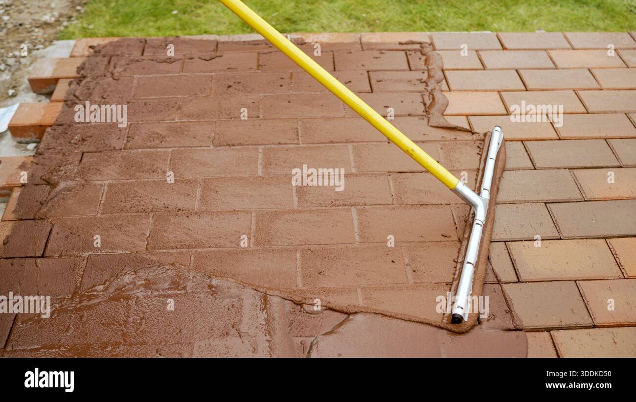 Applicazione del composto di Malta sul nuovo patio con pietre per pavimentazione Foto Stock