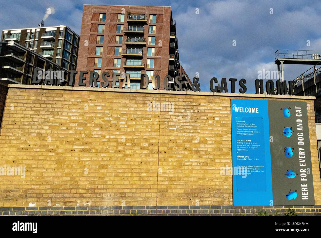 L'esterno di Battersea Dogs and Cats Home con cartellonistica di benvenuto e i moderni appartamenti circostanti a Londra Foto Stock