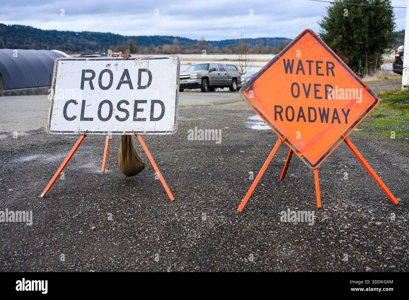 Le indicazioni per l'allagamento della strada sono chiuse e il diamante arancione Water Over Roadway Foto Stock