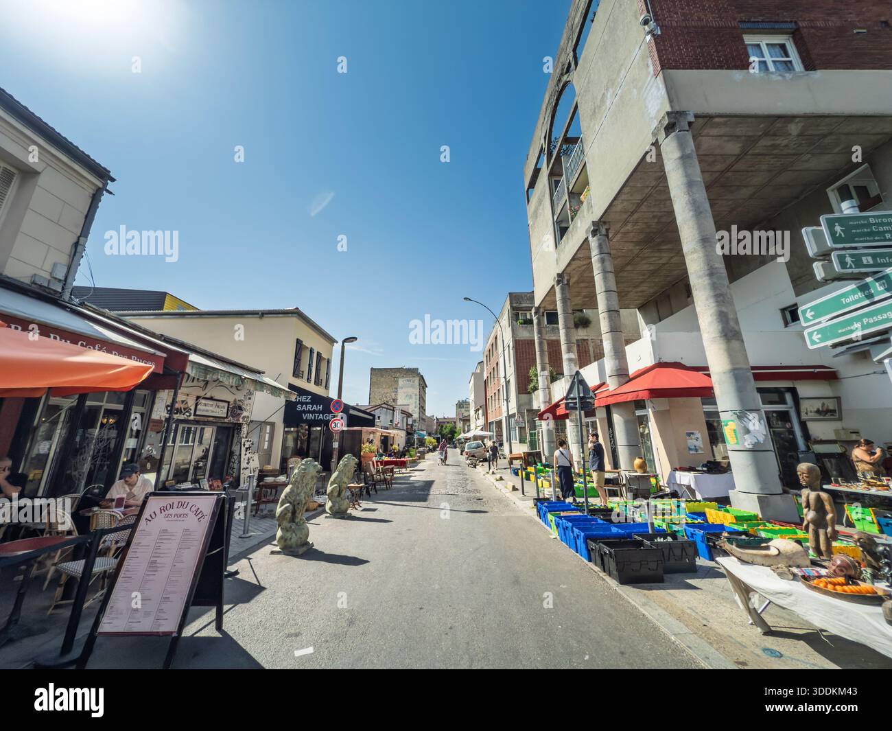 PARIGI, FRANCIA - 22 GIUGNO 2025: Una strada soleggiata al famoso mercato delle pulci di Parigi, Les Puces de Clignancourt, con bancarelle e negozi. Foto Stock