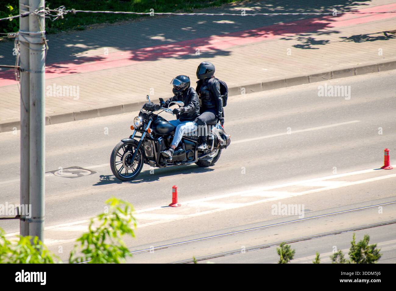 Un motociclista su una moto che viaggia per strada in città. Foto Stock