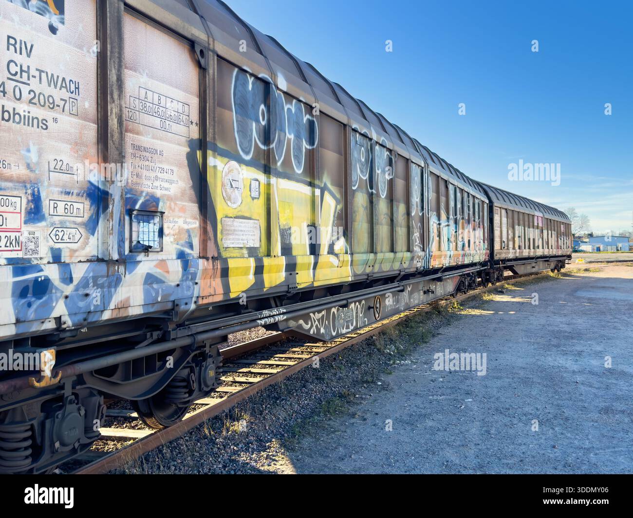 Ferrovia con vagoni merci con graffiti colorati Foto Stock