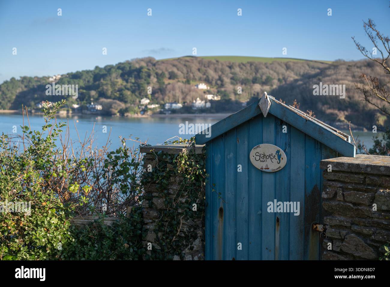 Cancello di legno blu con un cartello, per il cavalluccio marino, Salcombe, girato alla vigilia di un nuovo anno, inverno, con East Portlemouth in lontananza Foto Stock