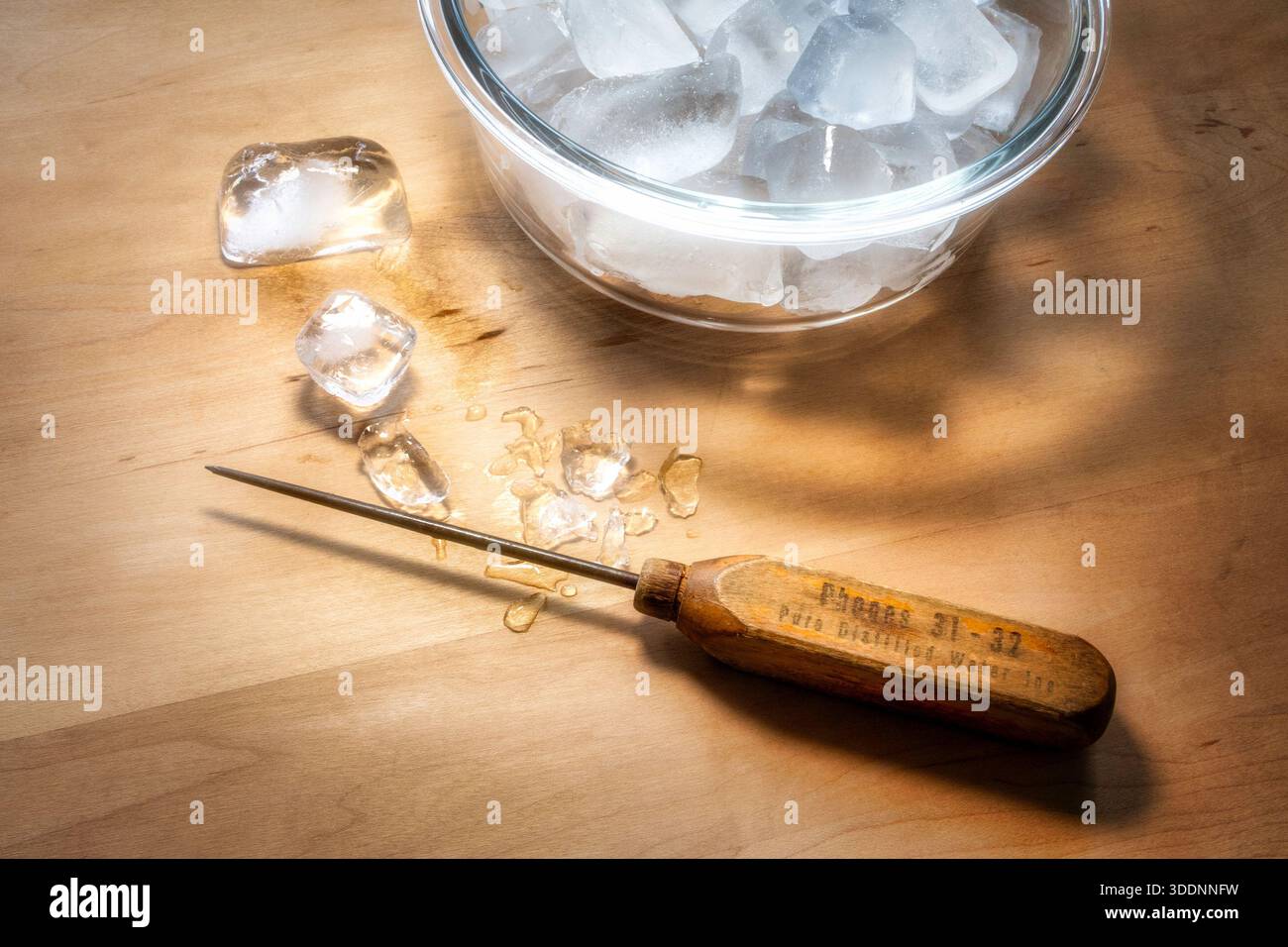 Una raccolta di ghiaccio anticato con un manico in legno su un tagliere con ghiaccio, 2025, Stati Uniti Foto Stock