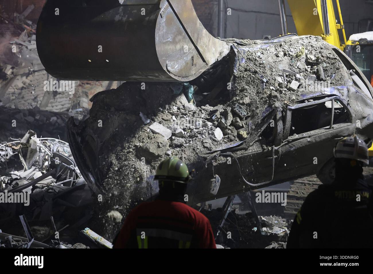 Non esclusivo: Un soccorritore osserva il funzionamento di attrezzature speciali durante gli sforzi di pulizia a seguito di un attacco missilistico russo su un resid a più piani Foto Stock