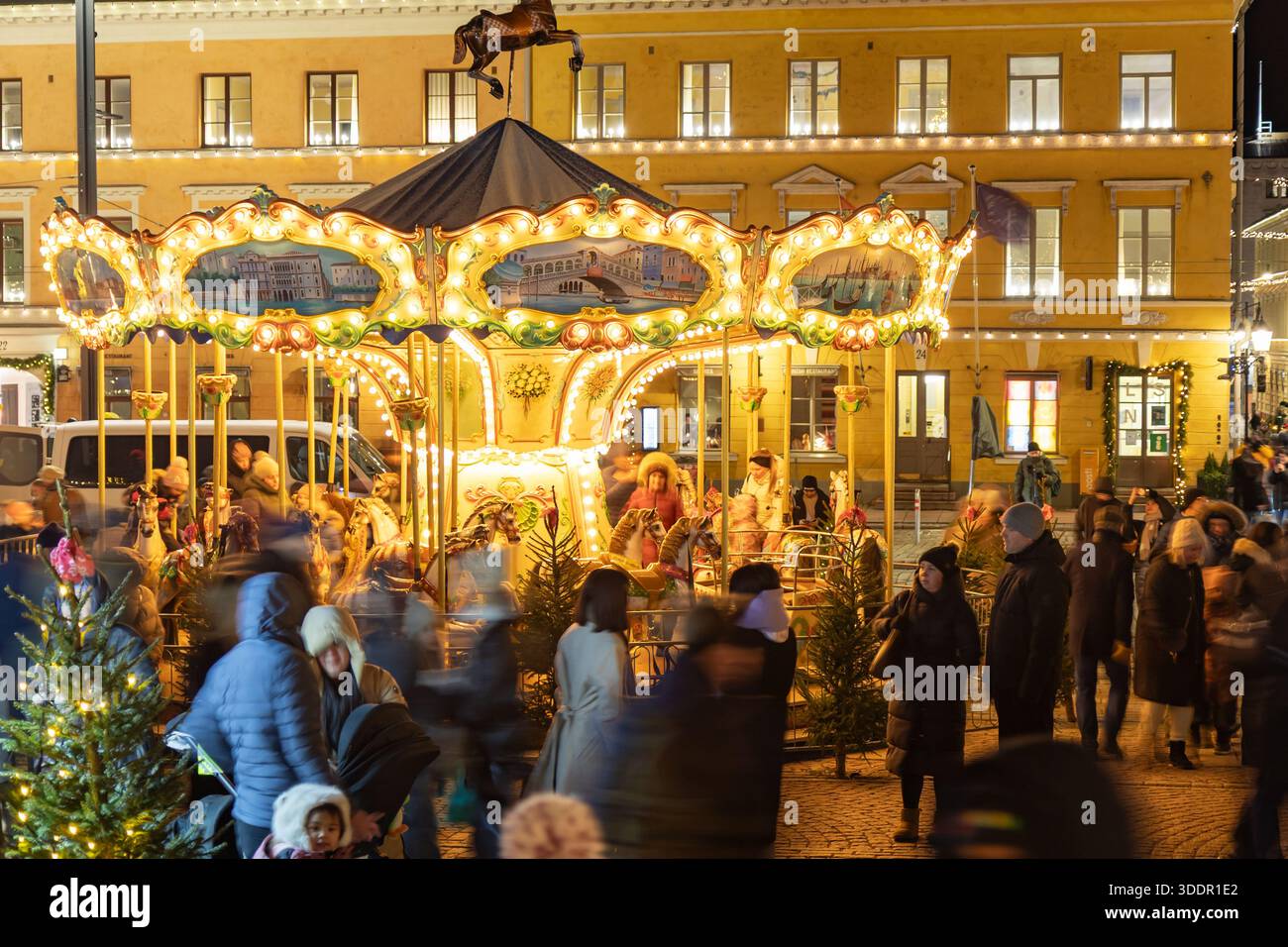 Helsinki, Finlandia - 22 dicembre 2025: Mercatino di Natale di Helsinki Tuomaan Markkinat in Piazza del Senato con giostra libera in stile retrò e visitatori Foto Stock