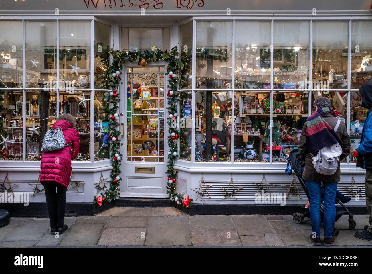 La gente guarda nella finestra di Un negozio di giocattoli a Canterbury nel periodo natalizio, Canterbury, Kent, Regno Unito. Foto Stock