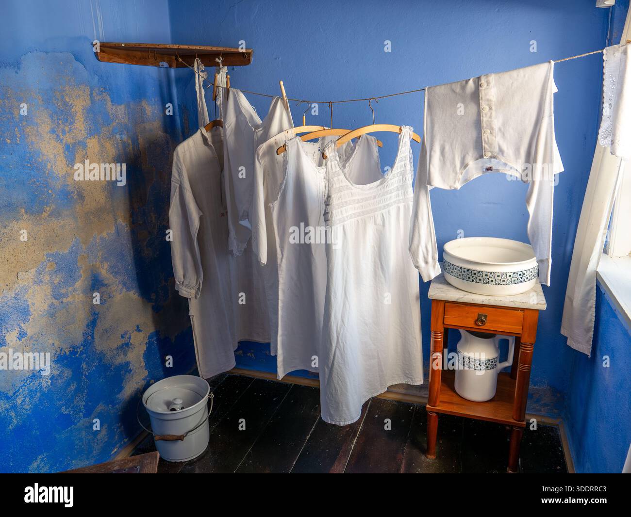 Interno della lavanderia con indumenti lavati appesi ad asciugare in un'ex casa residenziale del museo Farvergården nella città vecchia di Ebeltoft, Jutland, Danimarca Foto Stock