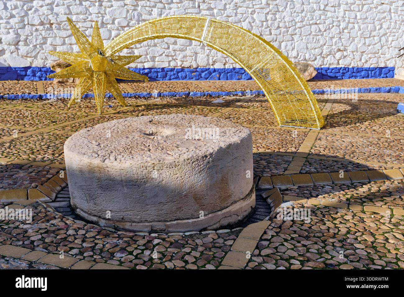 Vista del villaggio di campo de Criptana a la Mancha in Spagna, caratterizzato da un set di pietre millenarie e da un arco stellato dorato parte del percorso dei mulini a vento di Don Chisciotte molto popolare Foto Stock
