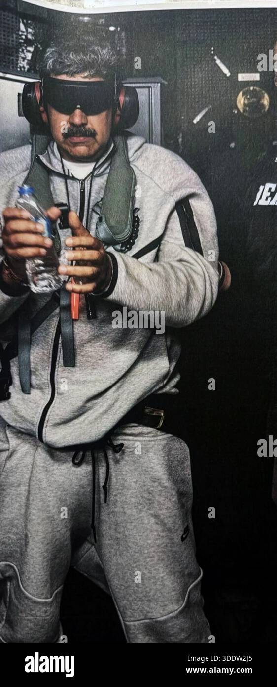 Nicolas Maduro a bordo della USS Iwo Jima. Foto del governo degli Stati Uniti. 3 gennaio 2026. Maduro indossa una tuta grigia, occhiali protettivi avvolgenti e cuffie, mentre viene scortato da personale statunitense a seguito di un'operazione militare su larga scala a Caracas. Versione hires. Foto Stock