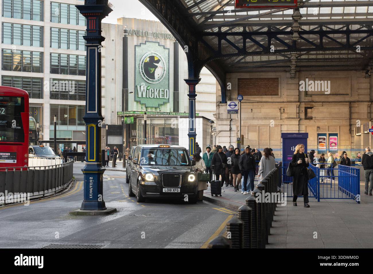 Persone e un taxi alla Victoria Station, Londra, vicino all'Apollo Victoria Theatre, casa di Wicked. Foto Stock